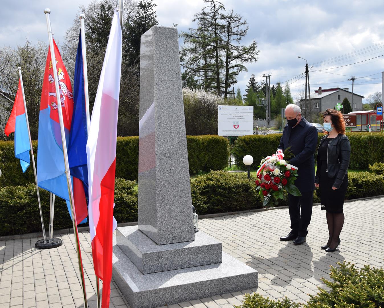 Wójt Gminy Mierzęcice Grzegorz Podlejski wraz z Zastępcą Wójta Gminy Mierzęcice Iwoną Pańtą składają kwiaty pod pomnikiem