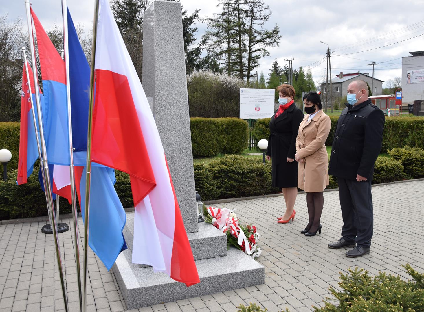 Przewodnicząca Rady Gminy Mierzęcice Monika Dyraga, Wiceprzewodniczący Rady Gminy Przemysław Paszewski oraz Radna Gminy Mierzęcice Katarzyna Burczyk składają kwiaty pod pomnikiem