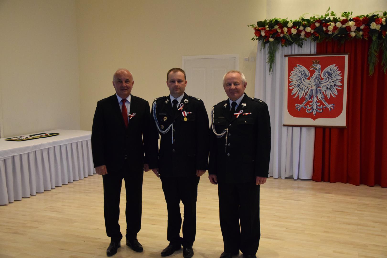 Zdjęcie przedstawia moment odznaczania zasłużonych członków straży