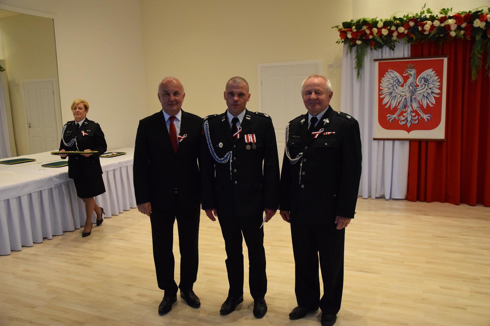 Zdjęcie przedstawia moment odznaczania zasłużonych członków straży