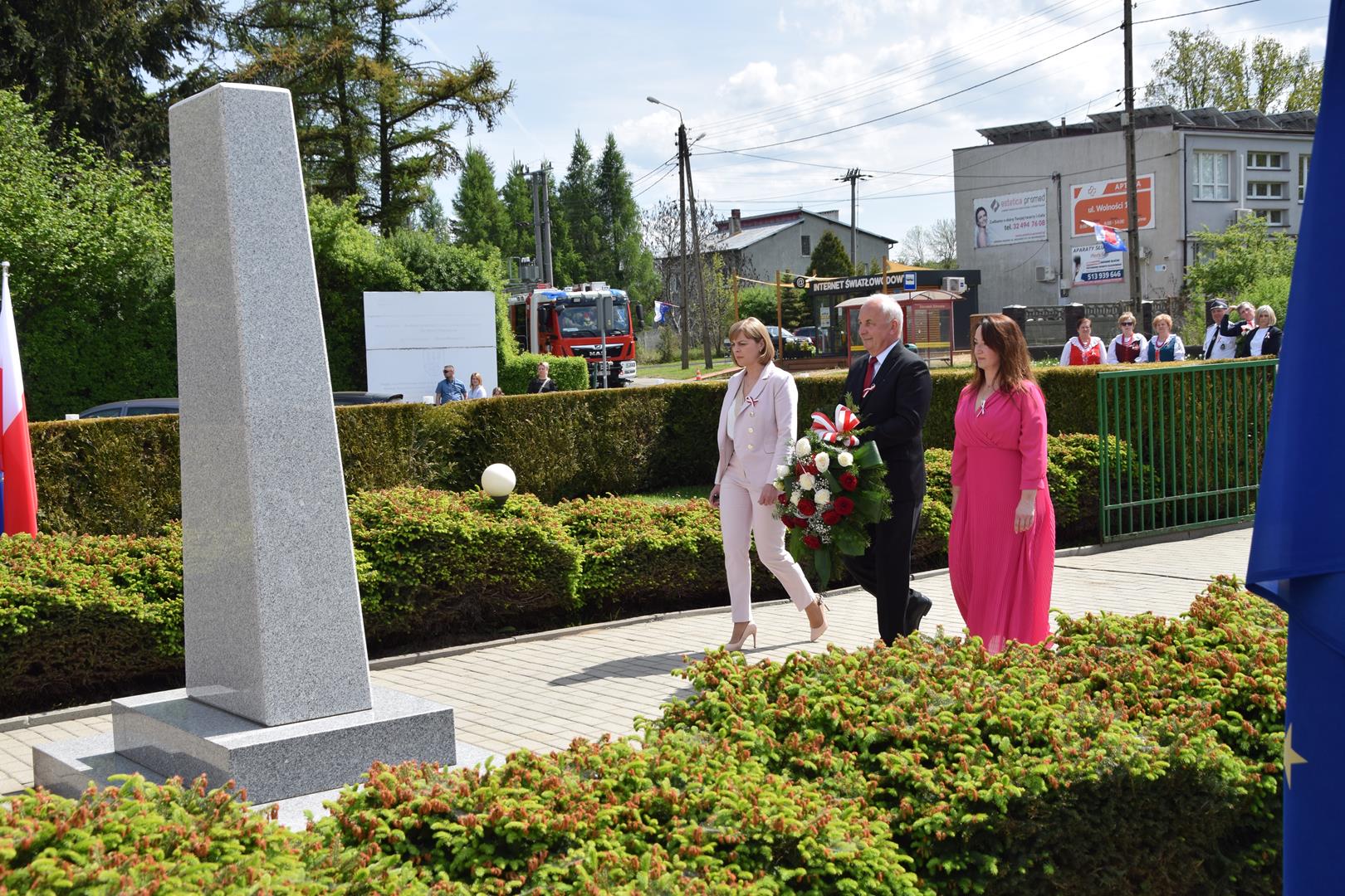 Zdjęcie przedstawia moment składania kwiatów pod pomnikiem przez Wójta Gminy Mierzęcice Grzegorza Podlejskiego, zastępcę wójta Iwonę Pańtę oraz skarbnik gminy Agnieszkę Frączek