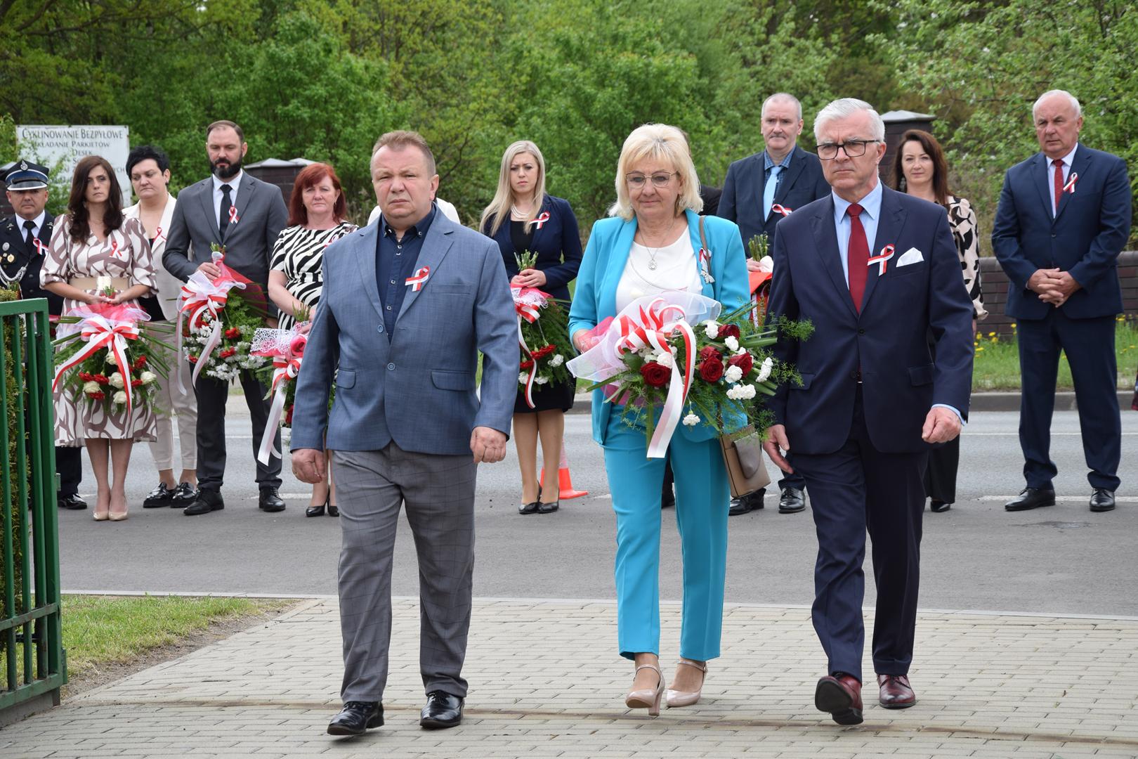Zdjęcie przedstawia moment składania kwiatów pod pomnikiem przez delegację Radnych Gminy Mierzęcice