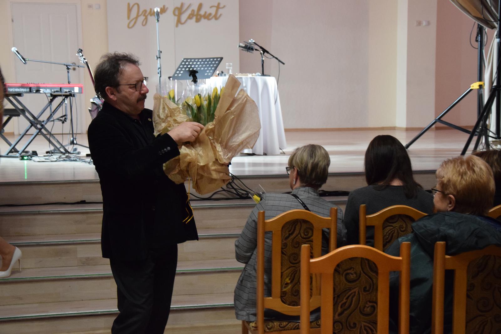 zdjęcie Zbigniewa Zamachowskiego rozdającego kwiaty
