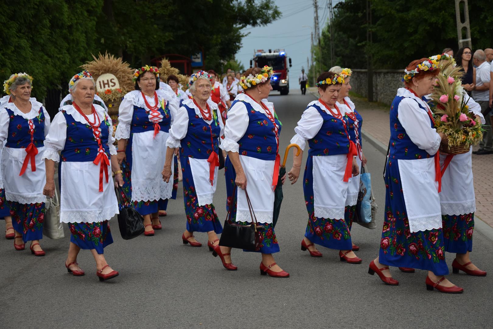 Zdjęcie przedstawia fragment przemarszu - niesienie wieńca dożynkowego
