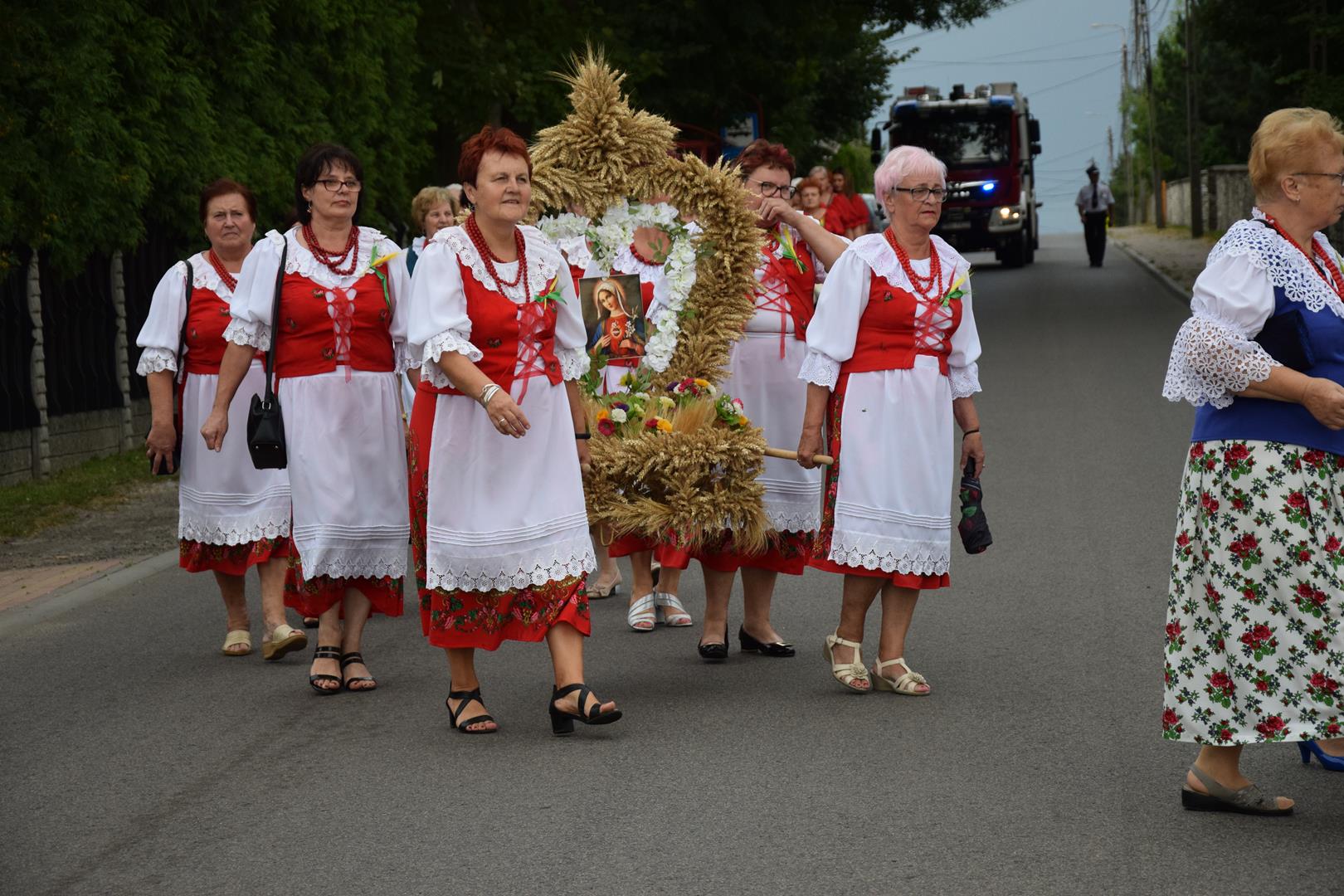Zdjęcie przedstawia fragment przemarszu - niesienie wieńca dożynkowego
