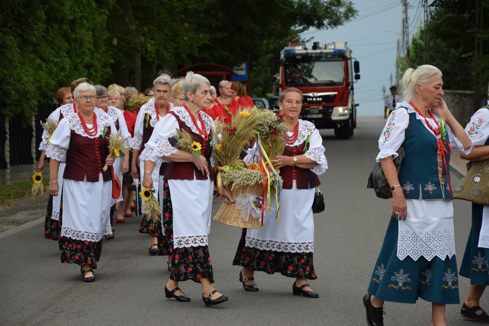 Zdjęcie przedstawia fragment przemarszu - niesienie wieńca dożynkowego