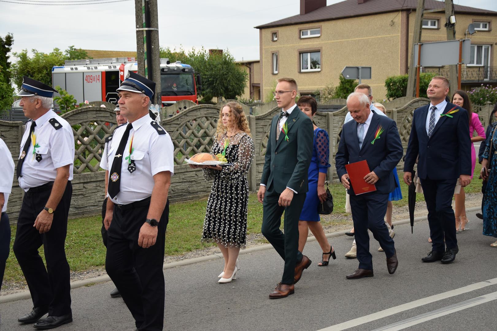 Zdjęcie przedstawia fragment przemarszu - starości dożynek niosący tradycyjny chleb