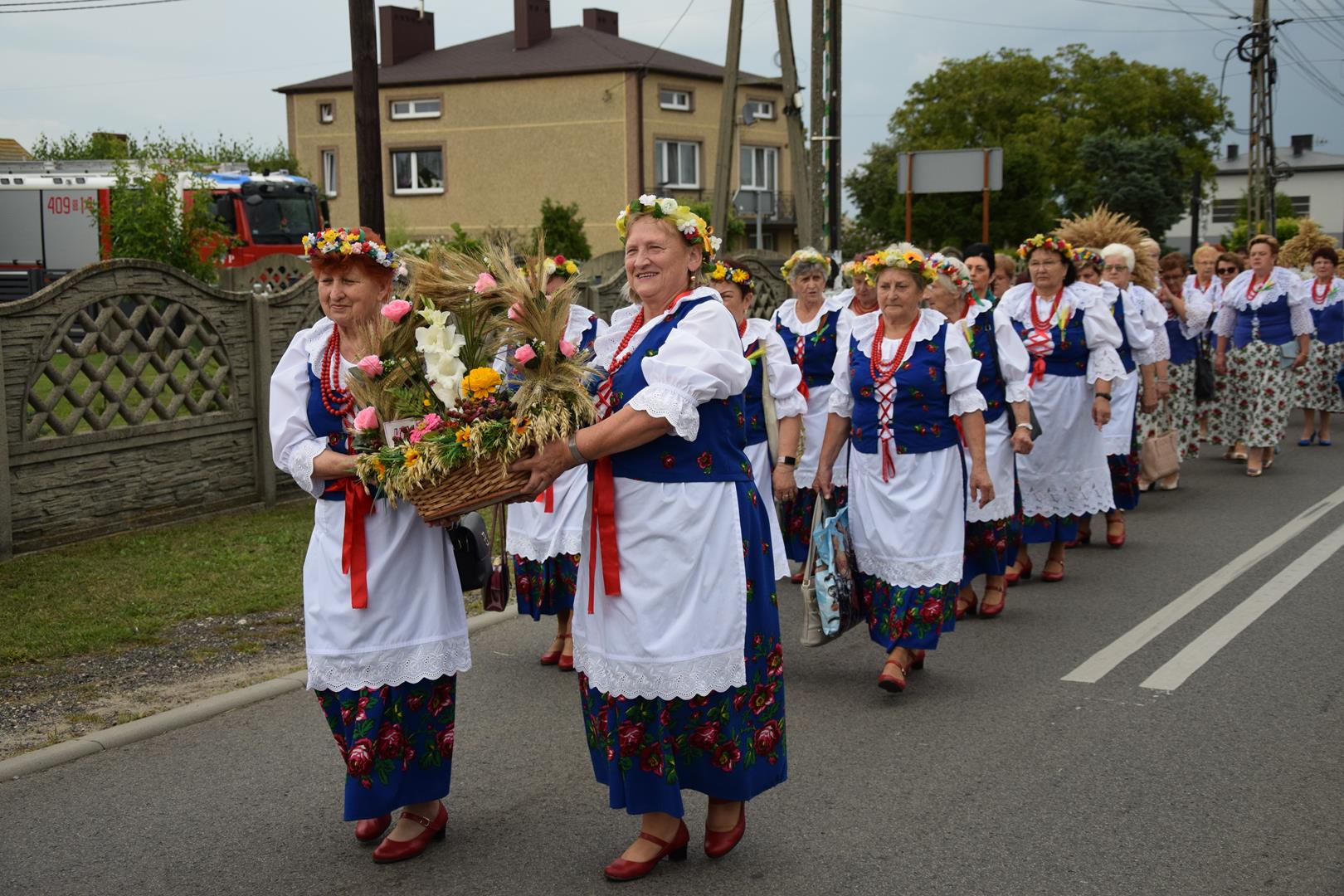 Zdjęcie przedstawia fragment przemarszu - niesienie wieńca dożynkowego