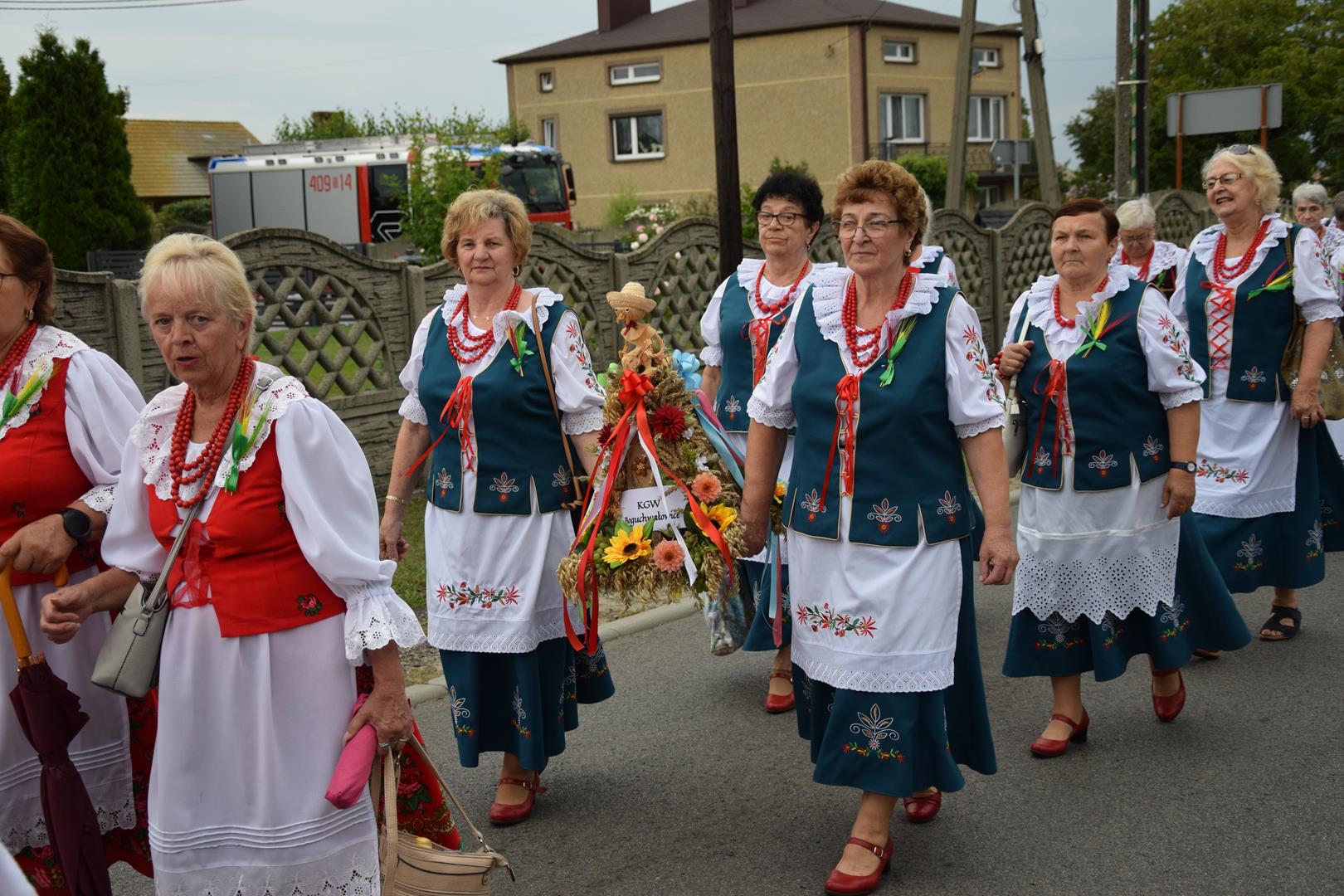 Zdjęcie przedstawia fragment przemarszu - niesienie wieńca dożynkowego