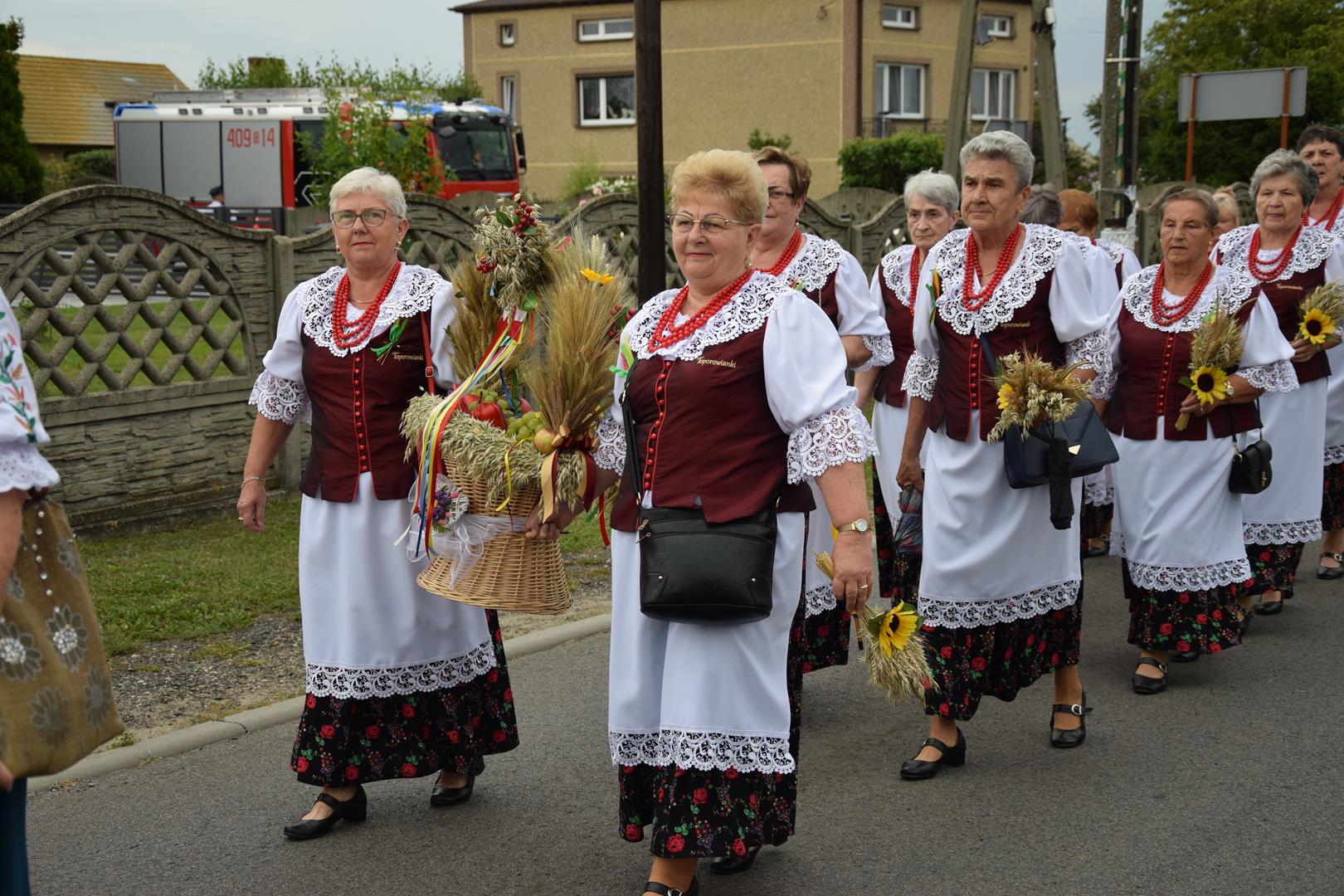 Zdjęcie przedstawia fragment przemarszu - niesienie wieńca dożynkowego