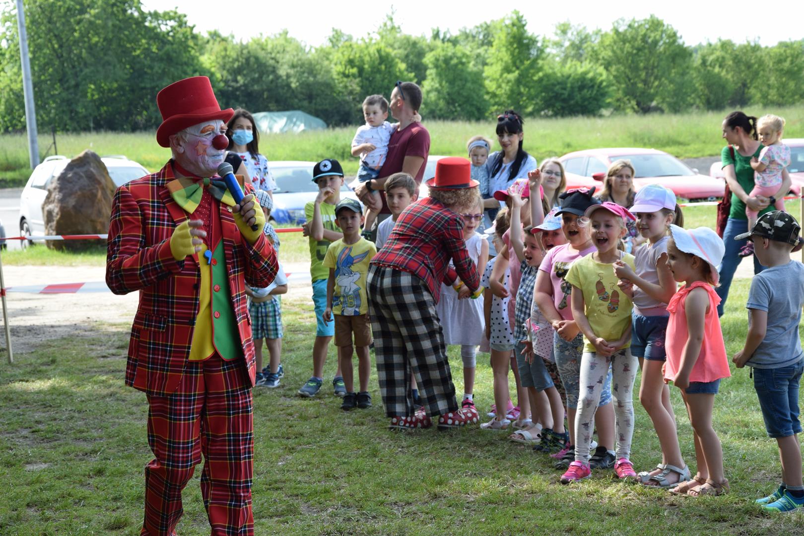 Zdjęcie przedstawiające klauna Rupherta przemawiającego do dzieci ustawionych w lini