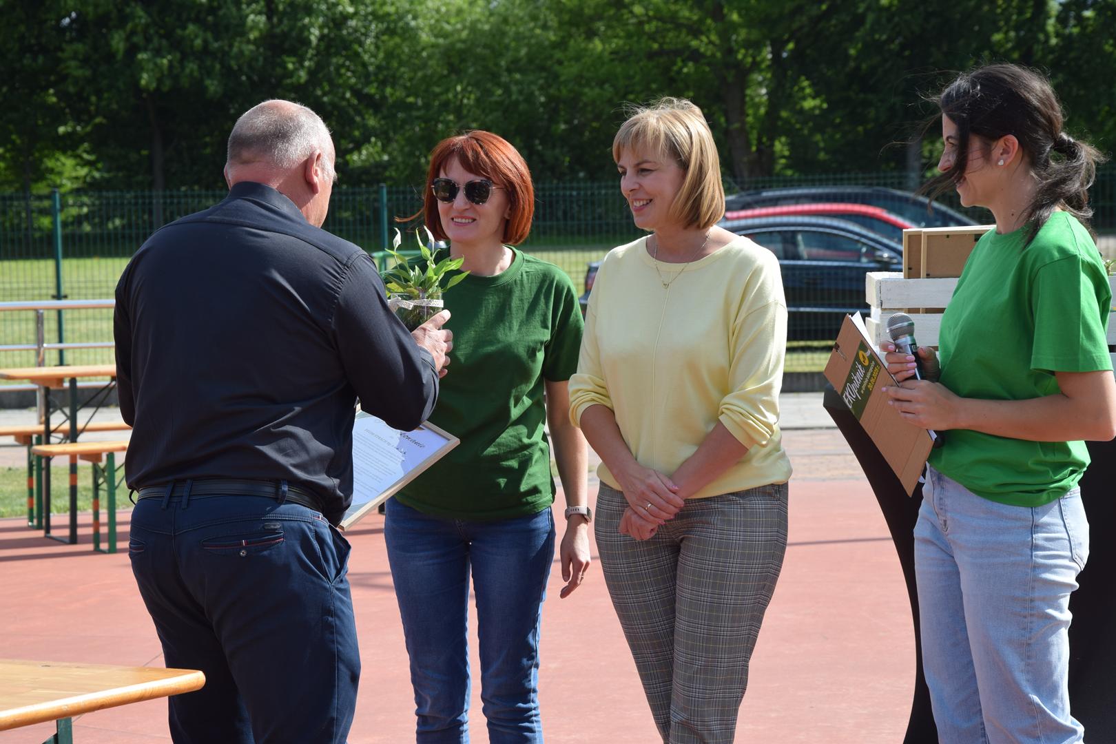Zdjęcie przedstawia moment wręczenie pamiątkowych eko prezentów dla wystawców