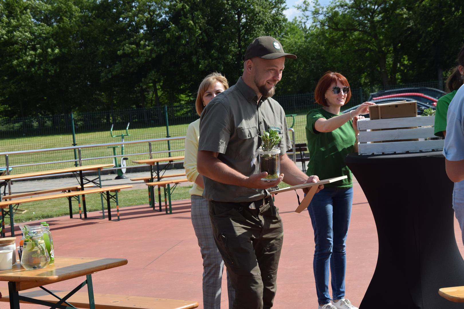 Zdjęcie przedstawia moment wręczenie pamiątkowych eko prezentów dla wystawców