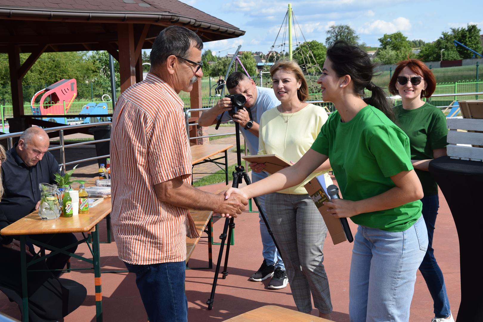 Zdjęcie przedstawia moment wręczenie pamiątkowych eko prezentów dla wystawców