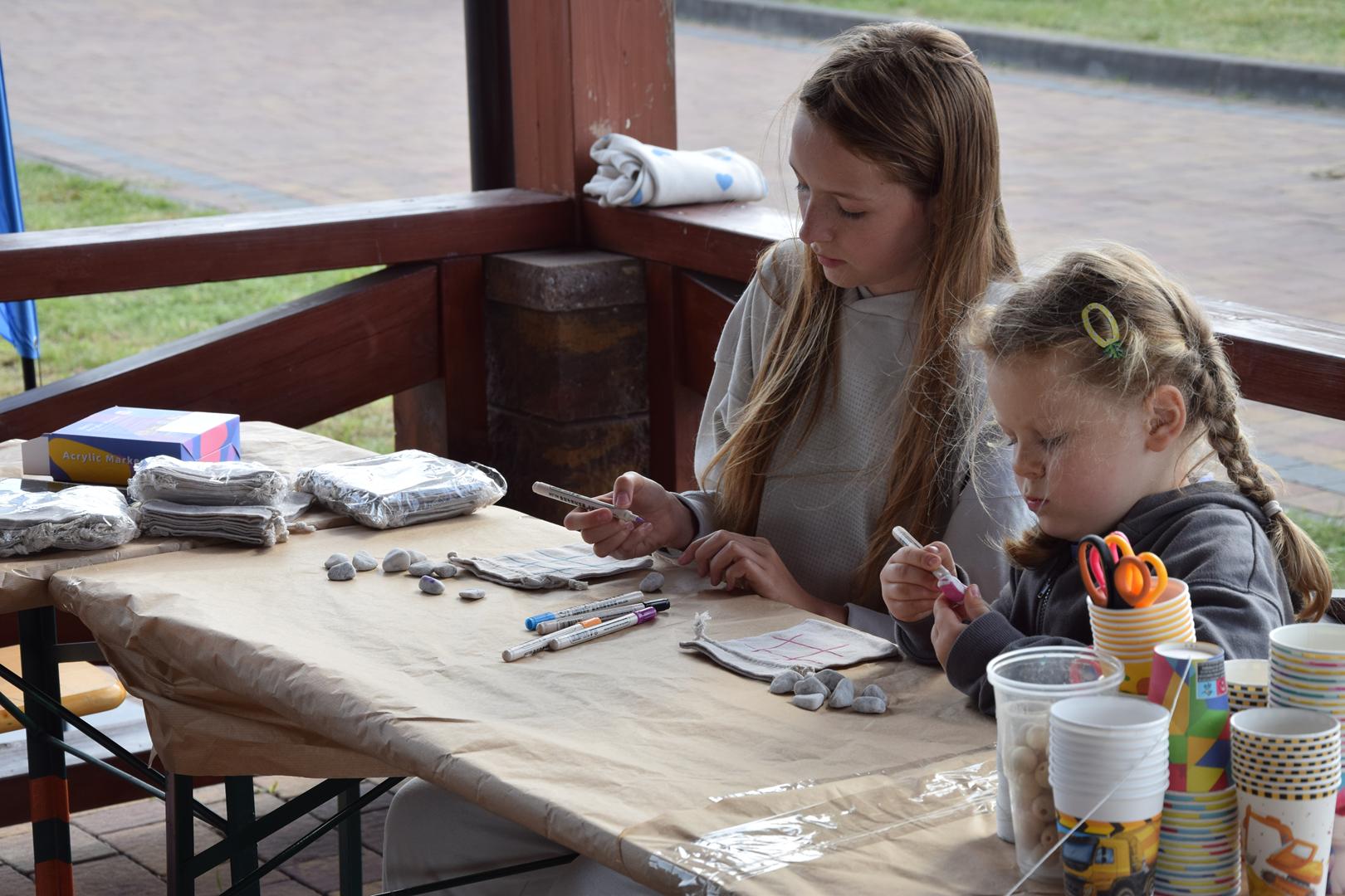 Zdjęcie przedstawia dzieci tworzące prace plastyczną na ekopikniku