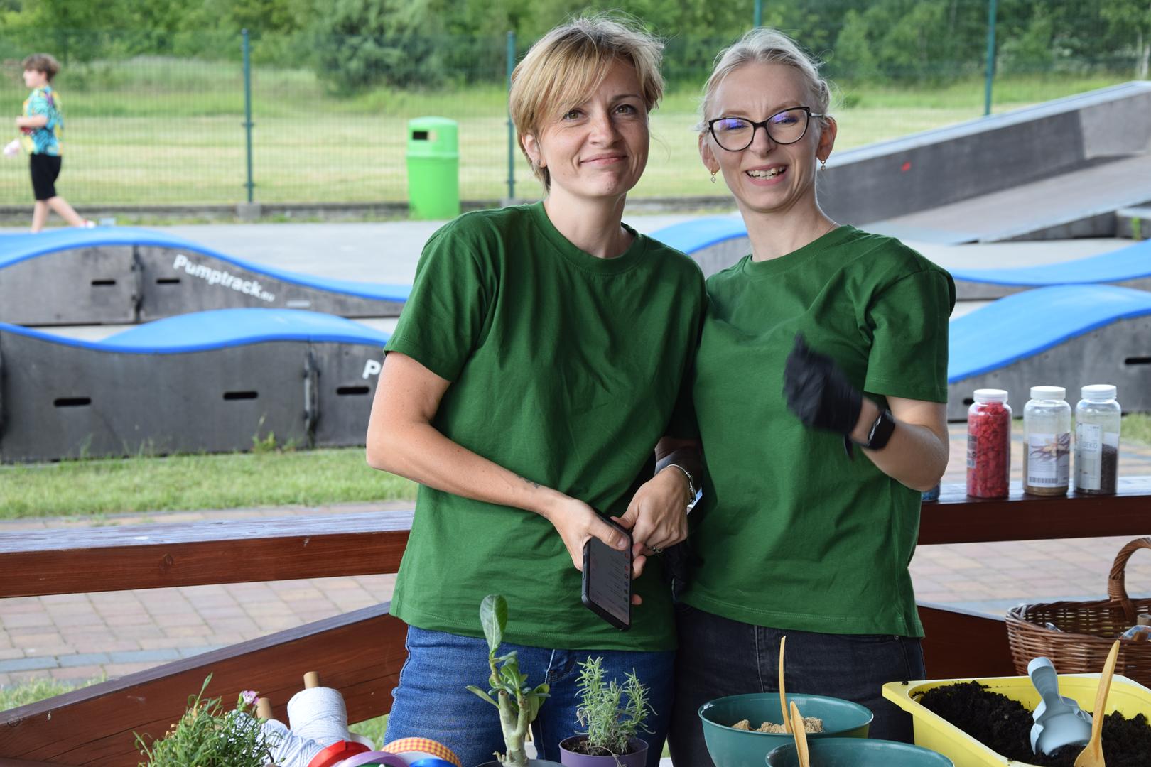 Zdjęcie przedstawia organizatorów pozujących do zdjęcia przy stanowisku lasów w&nbsp;szkle