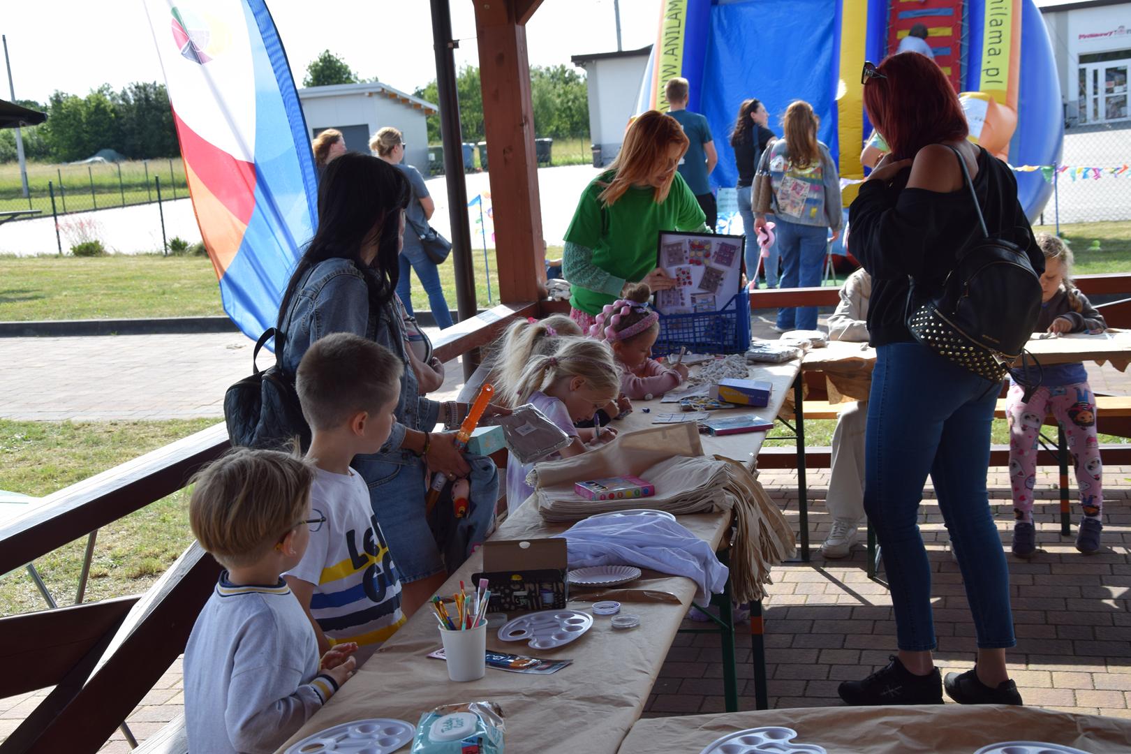 Zdjęcie przedstawia grupę dzieci tworzących prace plastyczne