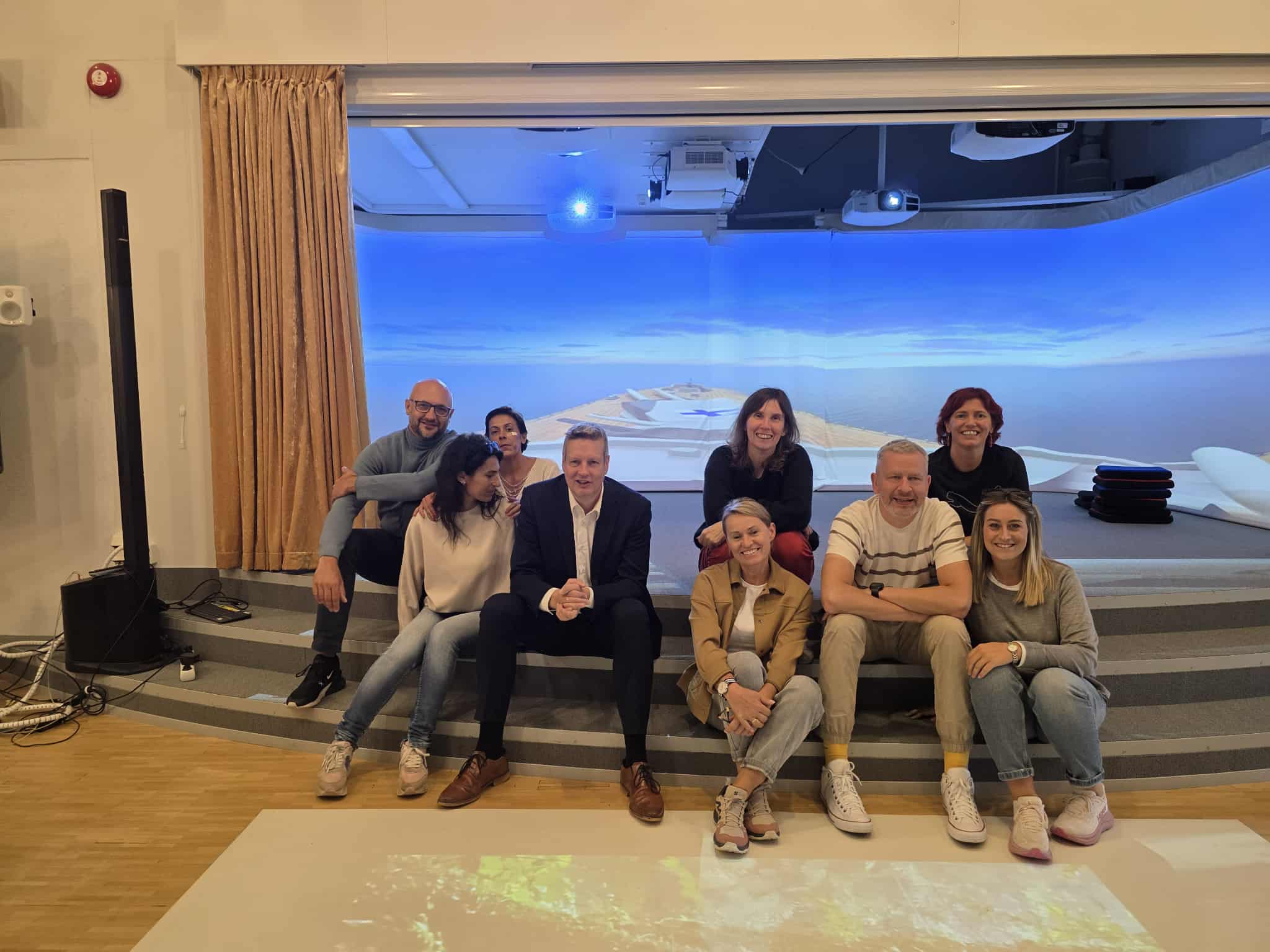 Zdjęcie przedstawia ludzi pozujących do zdjęcia grupowego