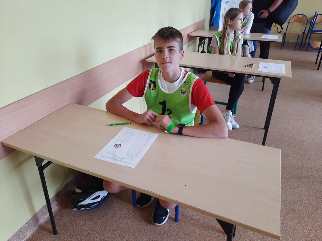 Zdjęcie przedstawia zawodnika siedzącego przy ławce