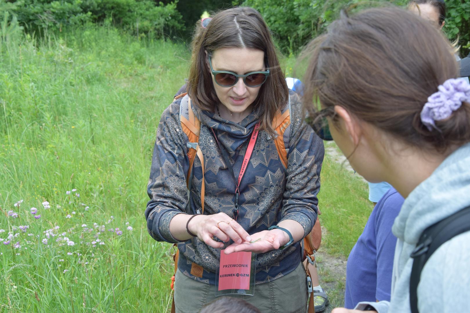 Zdjęcie przedstawia instruktora przedstawiającego kwiatostany roślin