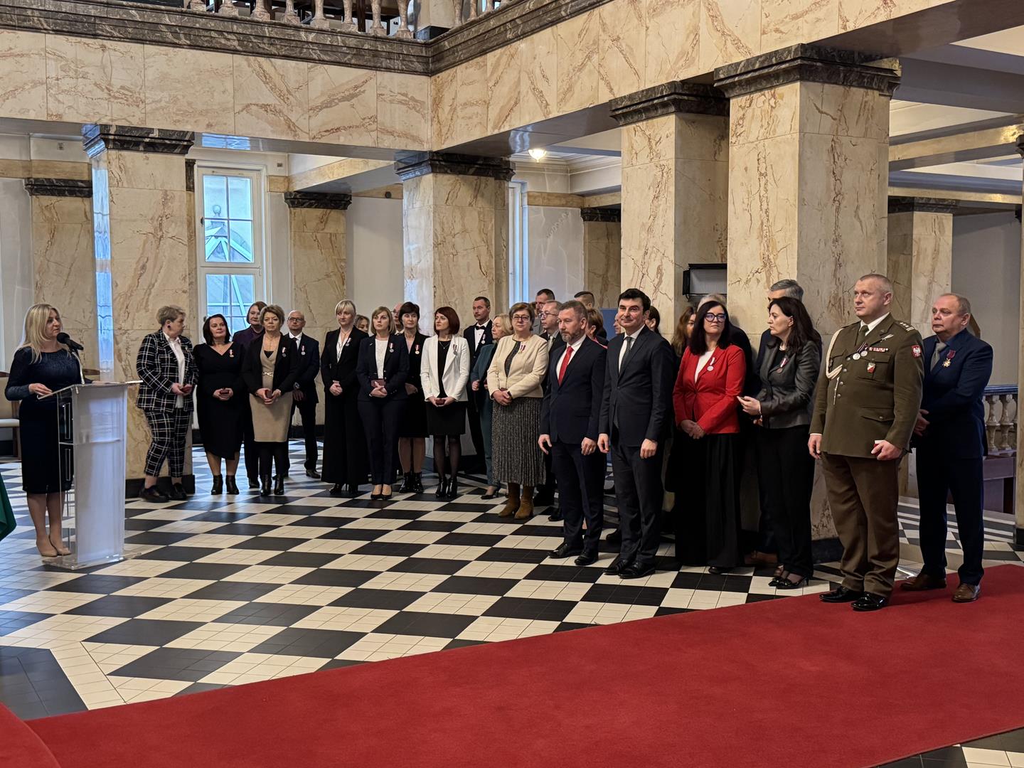 Zdjęcie przedstawia osoby biorące udział w uroczystości