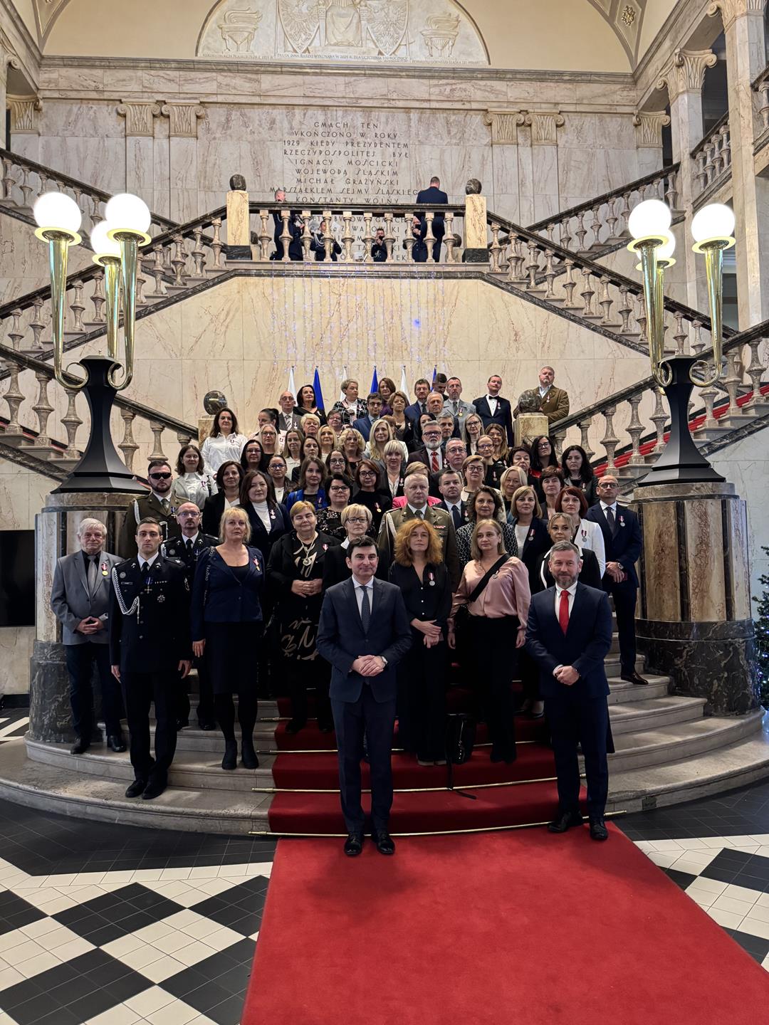Zdjęcie przedstawia osoby biorące udział w uroczystości
