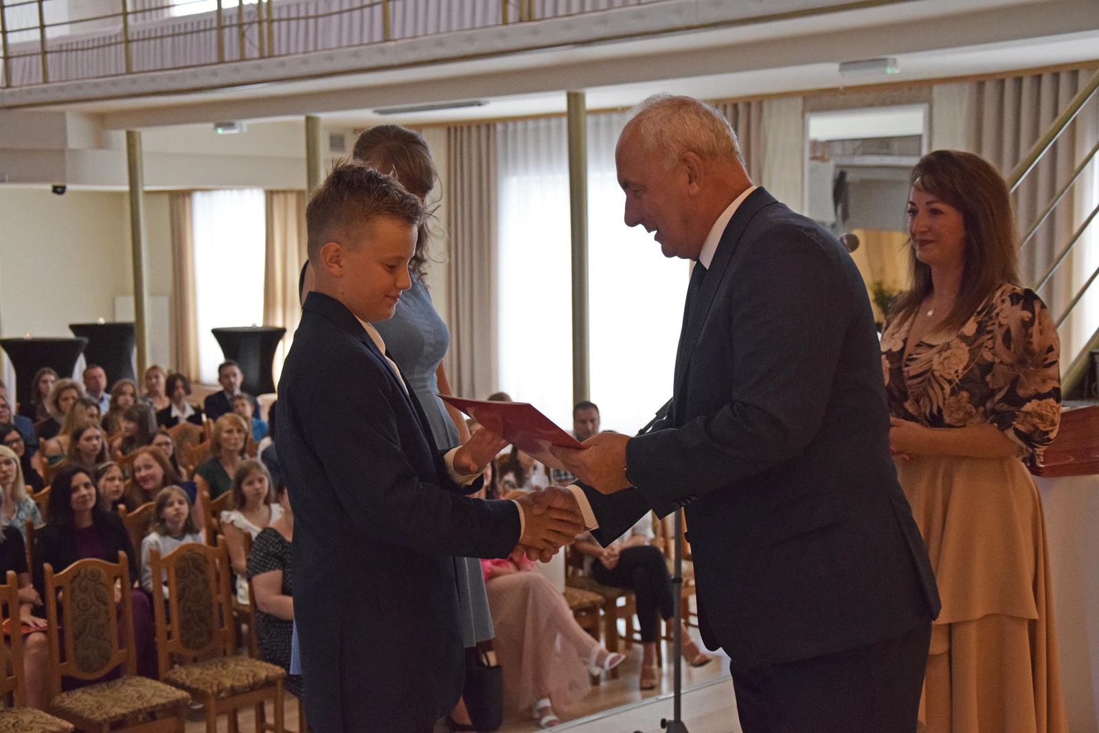 Zdjęcie przedstawiające moment rozdania nagród za wybite osiągnięcia i średnią ocen powyżej 5,2. Nagrody wręczali Wójt Gminy Mierzęcice Grzegorz Podlejski oraz Zastępca Wójta Gminy Mierzęcice Iwona Pańta.