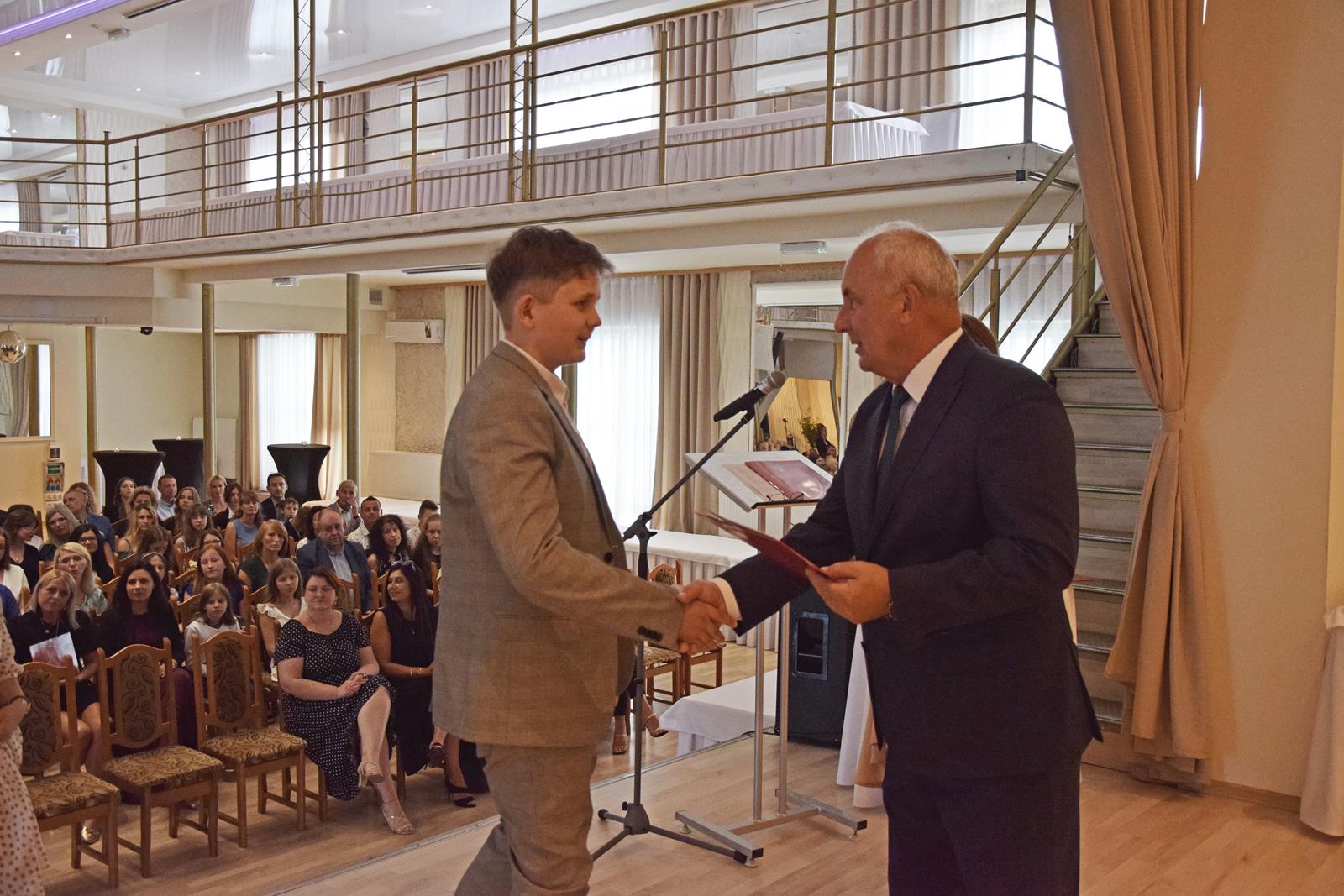 Zdjęcie przedstawiające moment rozdania nagród za wybite osiągnięcia i średnią ocen powyżej 5,2. Nagrody wręczali Wójt Gminy Mierzęcice Grzegorz Podlejski oraz Zastępca Wójta Gminy Mierzęcice Iwona Pańta.