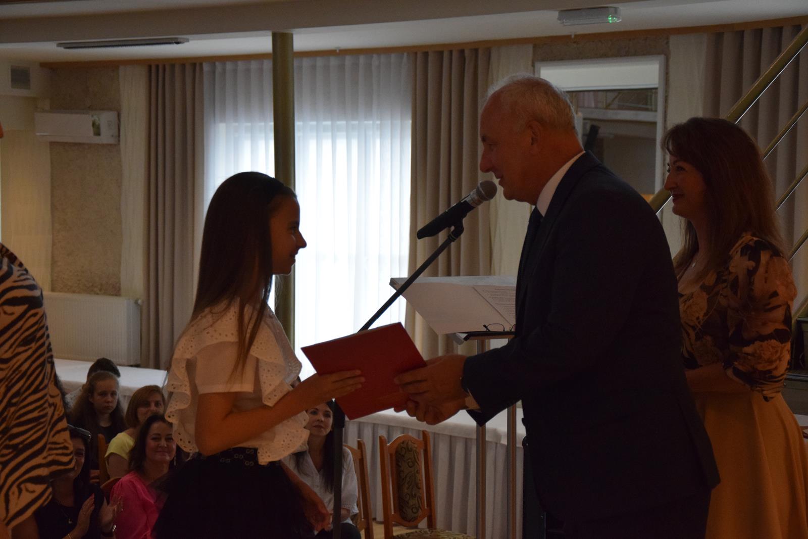 Zdjęcie przedstawiające moment rozdania nagród za wybite osiągnięcia i średnią ocen powyżej 5,2. Nagrody wręczali Wójt Gminy Mierzęcice Grzegorz Podlejski oraz Zastępca Wójta Gminy Mierzęcice Iwona Pańta.