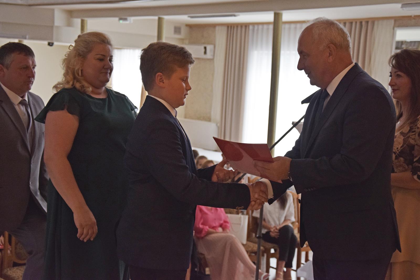 Zdjęcie przedstawiające moment rozdania nagród za wybite osiągnięcia i średnią ocen powyżej 5,2. Nagrody wręczali Wójt Gminy Mierzęcice Grzegorz Podlejski oraz Zastępca Wójta Gminy Mierzęcice Iwona Pańta.