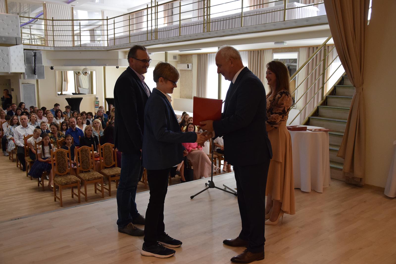 Zdjęcie przedstawiające moment rozdania nagród za wybite osiągnięcia i średnią ocen powyżej 5,2. Nagrody wręczali Wójt Gminy Mierzęcice Grzegorz Podlejski oraz Zastępca Wójta Gminy Mierzęcice Iwona Pańta.