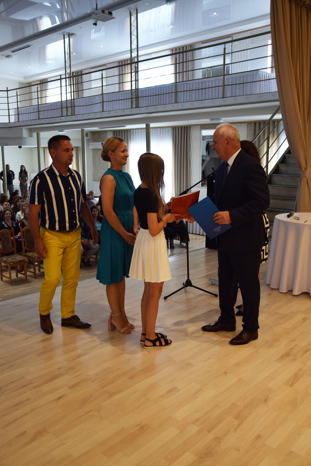 Zdjęcie przedstawia ucznia odbierającego nagrodę wójta