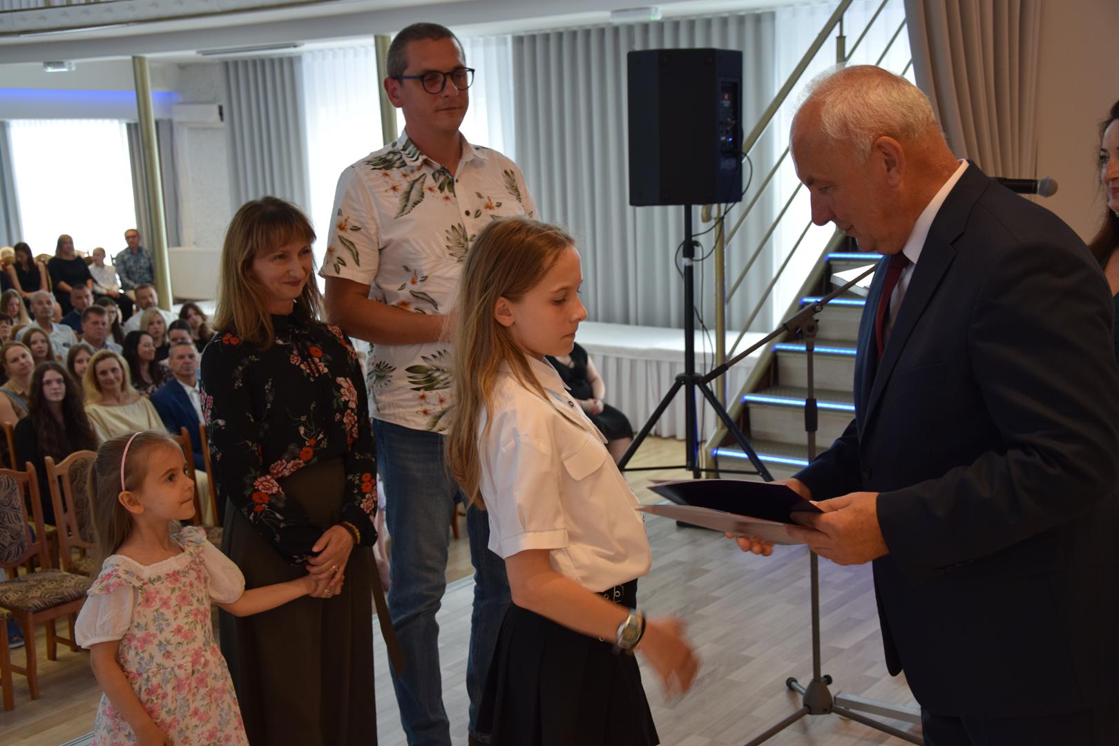 Zdjęcie przedstawia moment rozdania nagród i&nbsp;wyróżnień dla uczniów z&nbsp;najwyższą średnią ocen w&nbsp;Gminie Mierzęcice