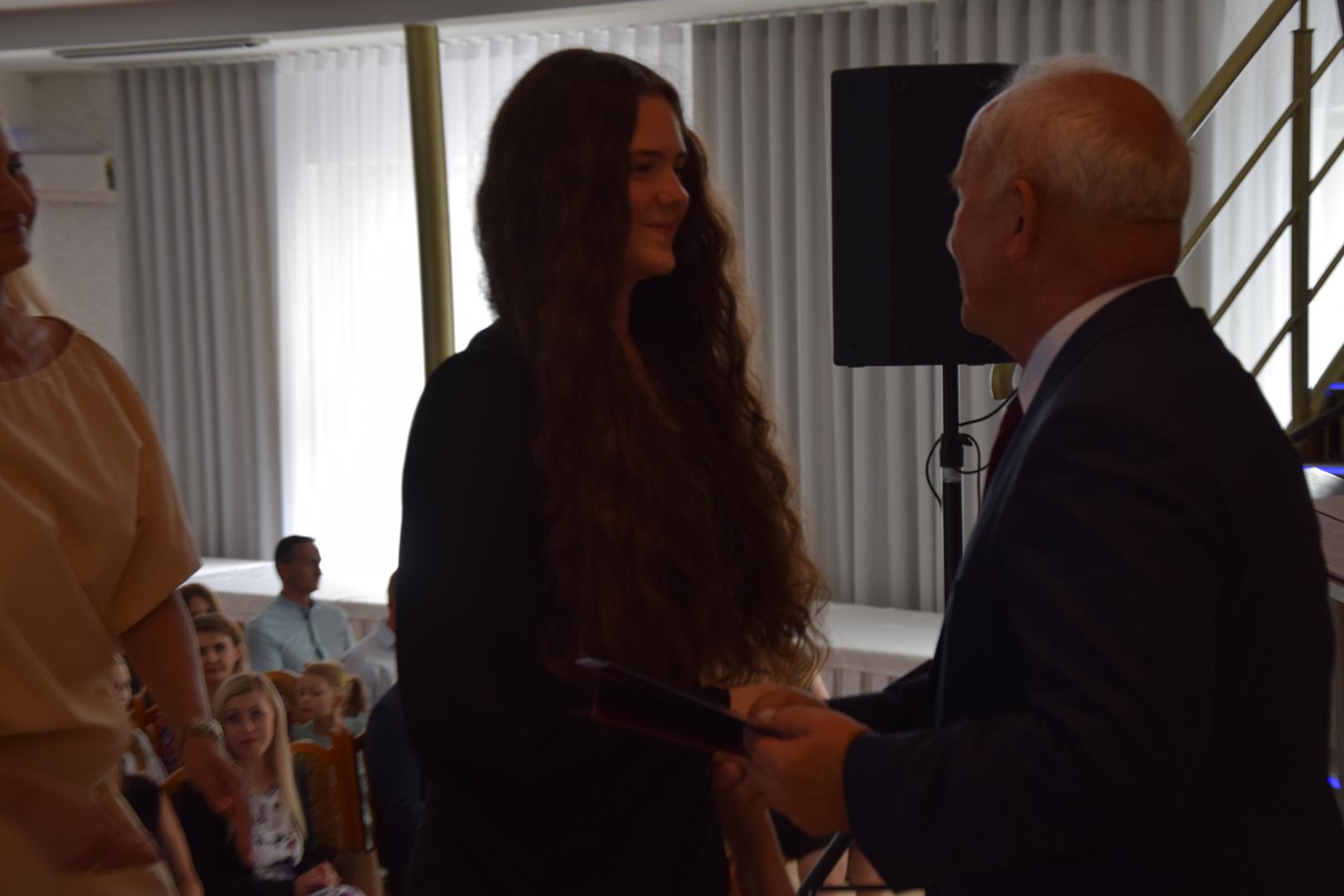 Zdjęcie przedstawia moment rozdania nagród i&nbsp;wyróżnień dla uczniów z&nbsp;najwyższą średnią ocen w&nbsp;Gminie Mierzęcice