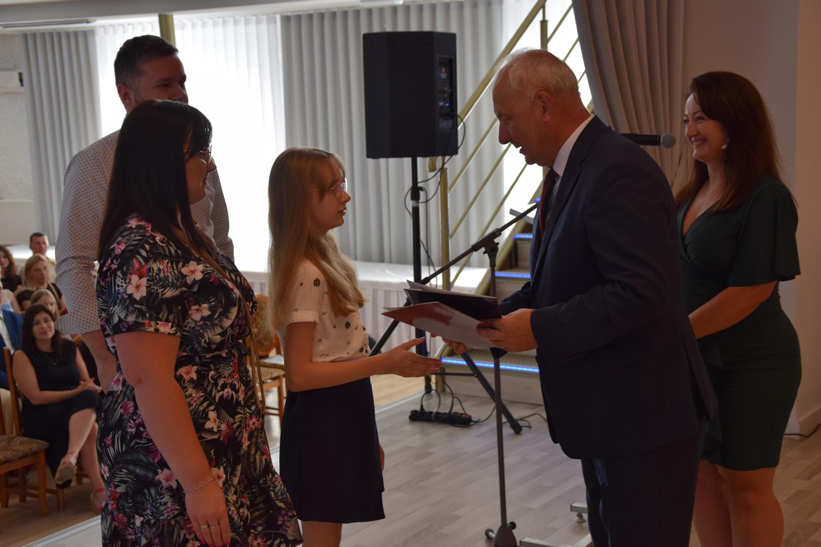 Zdjęcie przedstawia moment rozdania nagród i&nbsp;wyróżnień dla uczniów z&nbsp;najwyższą średnią ocen w&nbsp;Gminie Mierzęcice