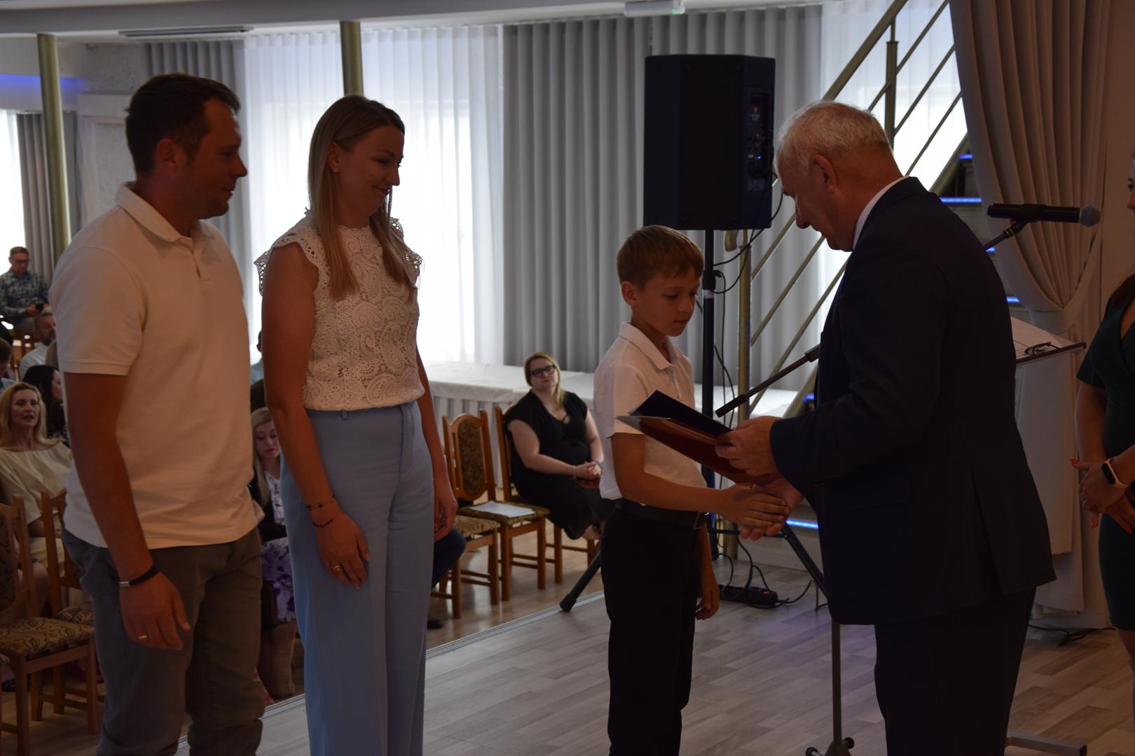 Zdjęcie przedstawia moment rozdania nagród i&nbsp;wyróżnień dla uczniów z&nbsp;najwyższą średnią ocen w&nbsp;Gminie Mierzęcice