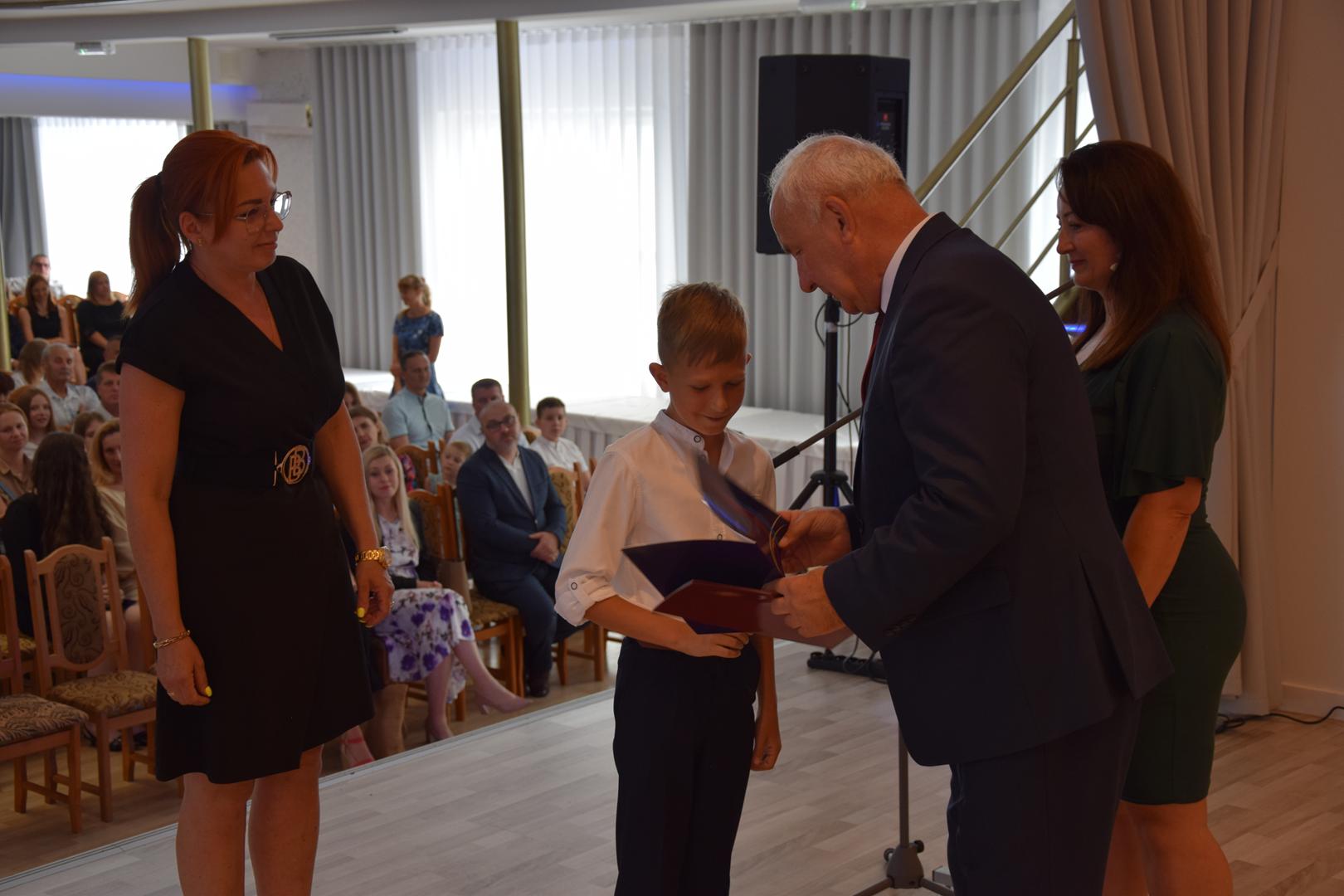 Zdjęcie przedstawia moment rozdania nagród i&nbsp;wyróżnień dla uczniów z&nbsp;najwyższą średnią ocen w&nbsp;Gminie Mierzęcice