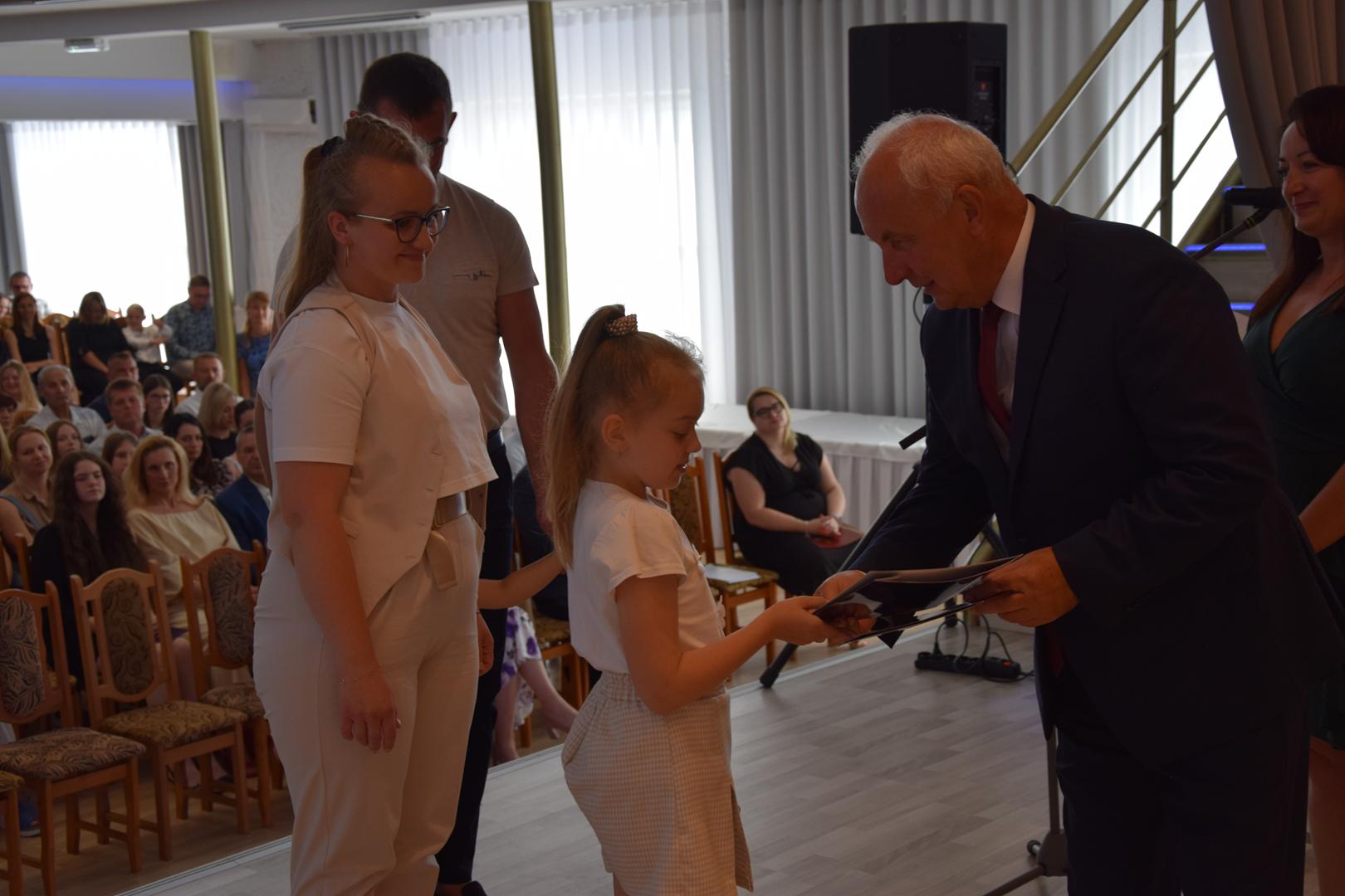 Zdjęcie przedstawia moment rozdania nagród i&nbsp;wyróżnień dla uczniów z&nbsp;najwyższą średnią ocen w&nbsp;Gminie Mierzęcice