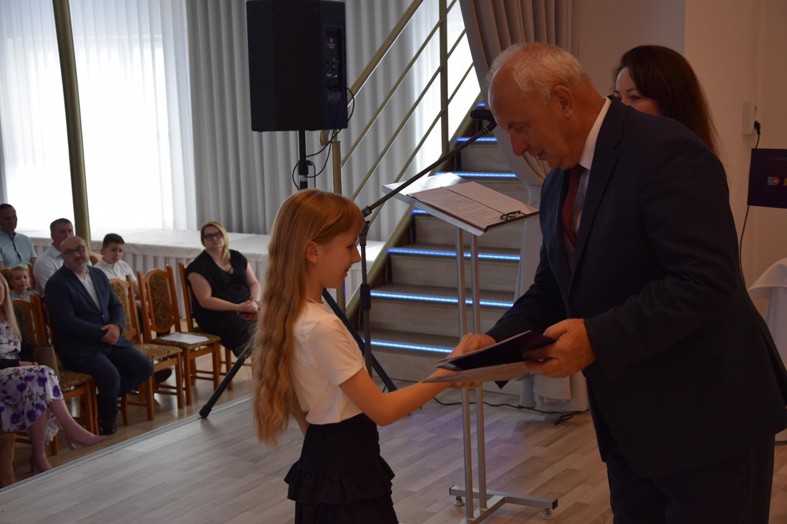 Zdjęcie przedstawia moment rozdania nagród i&nbsp;wyróżnień dla uczniów z&nbsp;najwyższą średnią ocen w&nbsp;Gminie Mierzęcice