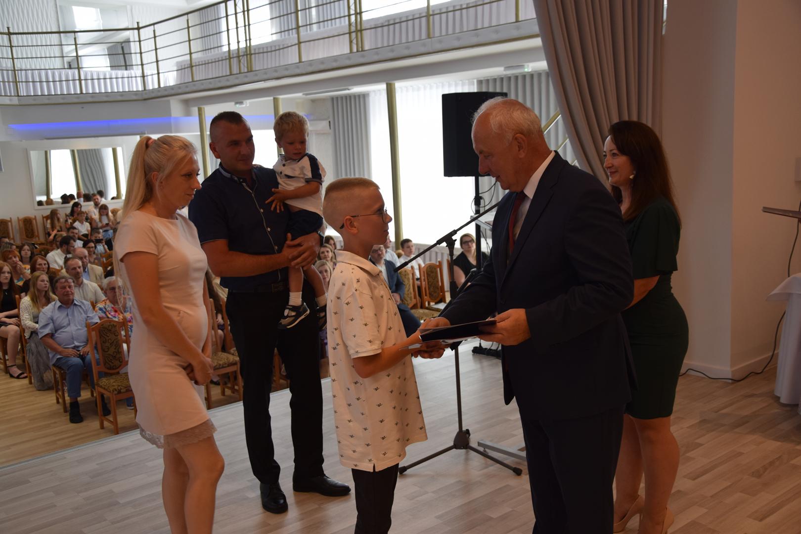 Zdjęcie przedstawia moment rozdania nagród i&nbsp;wyróżnień dla uczniów z&nbsp;najwyższą średnią ocen w&nbsp;Gminie Mierzęcice