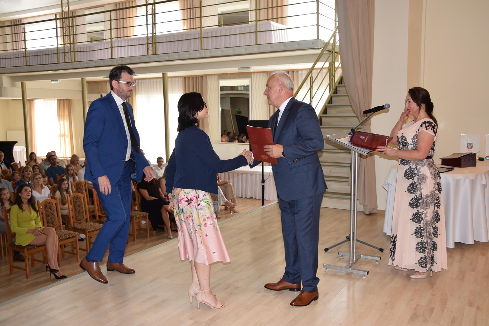 Zdjęcie przedstawia moment wręczenia dyplomów z okazji promocji ucznia zdolnego 2024