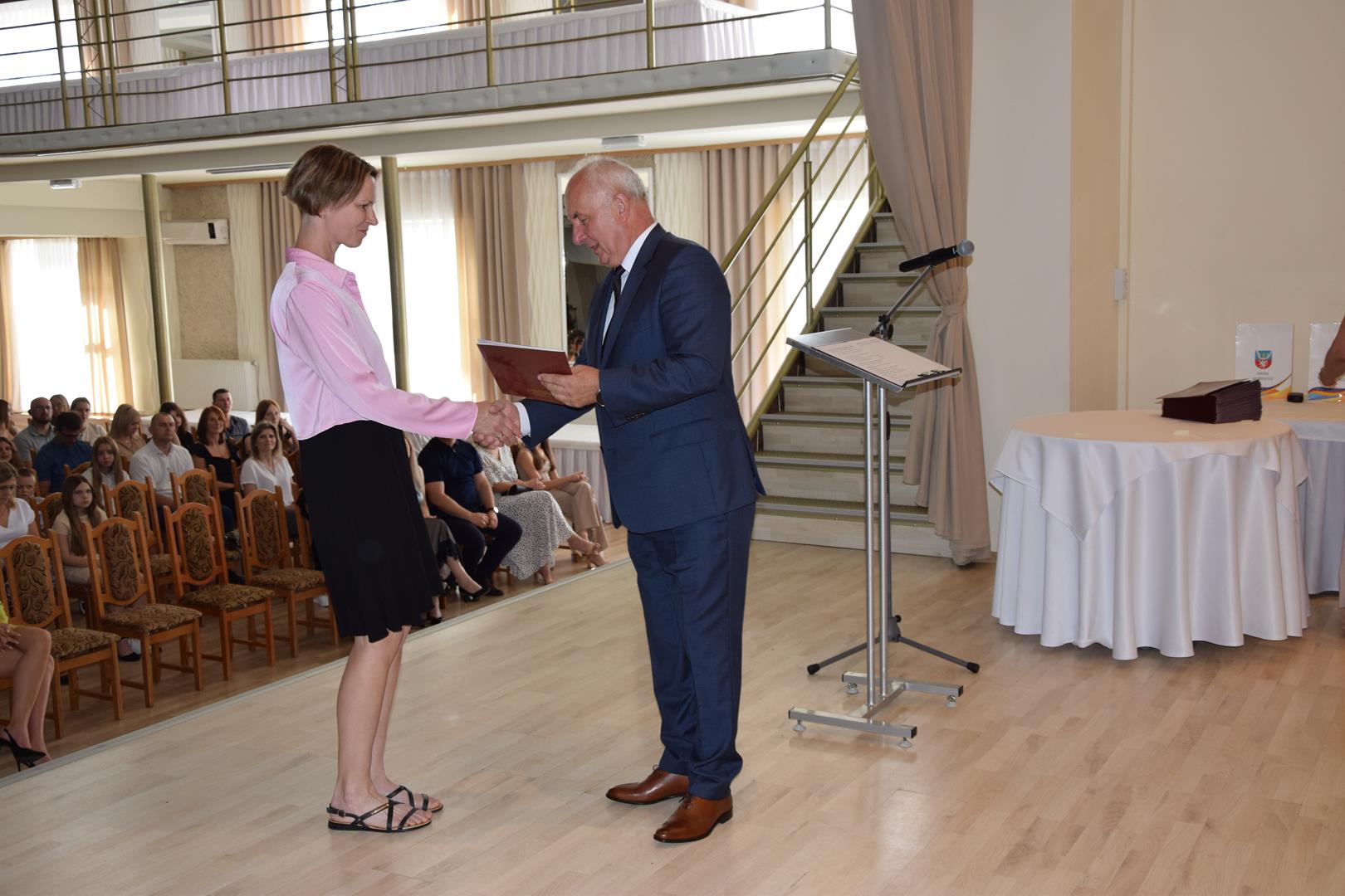 Zdjęcie przedstawia moment wręczenia dyplomów z okazji promocji ucznia zdolnego 2024