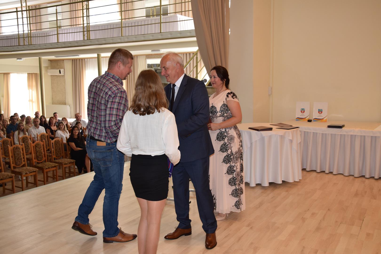 Zdjęcie przedstawia moment wręczenia dyplomów z okazji promocji ucznia zdolnego 2024