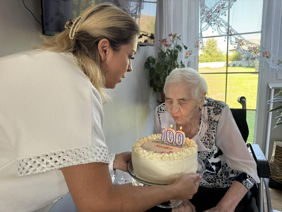 Zdjęcie przedstawia jubilatkę z&nbsp;tortem urodzinowym
