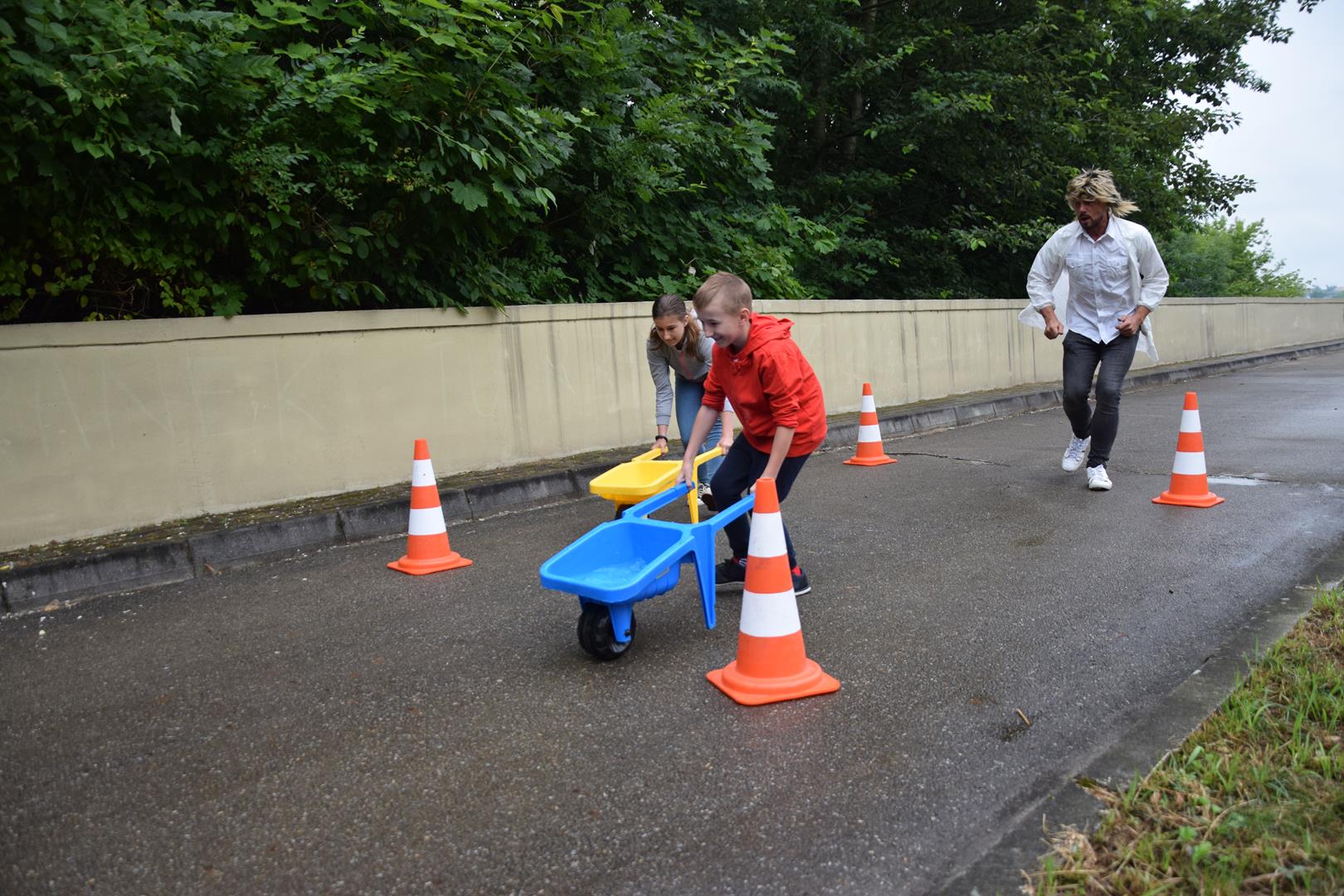 Zdjęcie przedstawiające dzieci biorące udział w animacjach - wyścig taczek z wodą