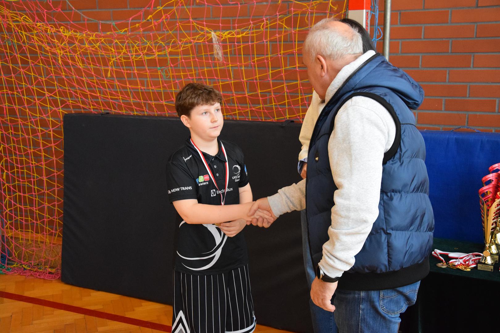 Zdjęcie przedstawia moment wręczania medali, dyplomów i&nbsp;pucharów