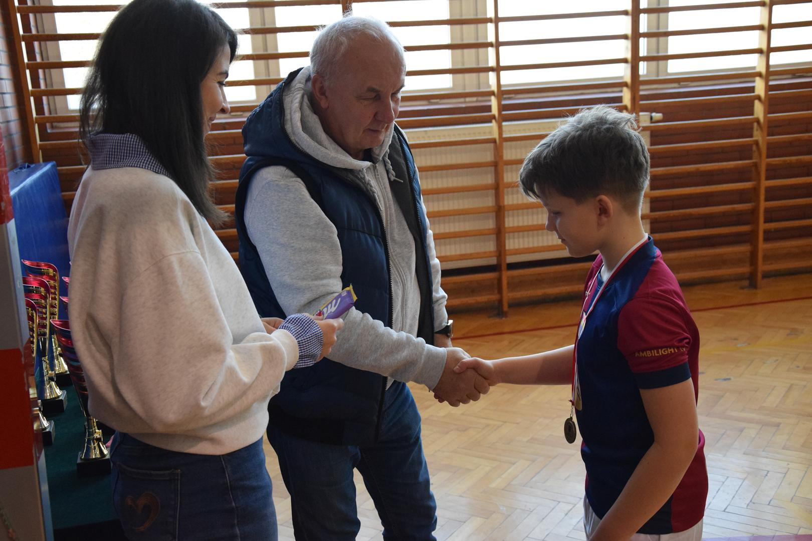 Zdjęcie przedstawia moment wręczania medali, dyplomów i&nbsp;pucharów