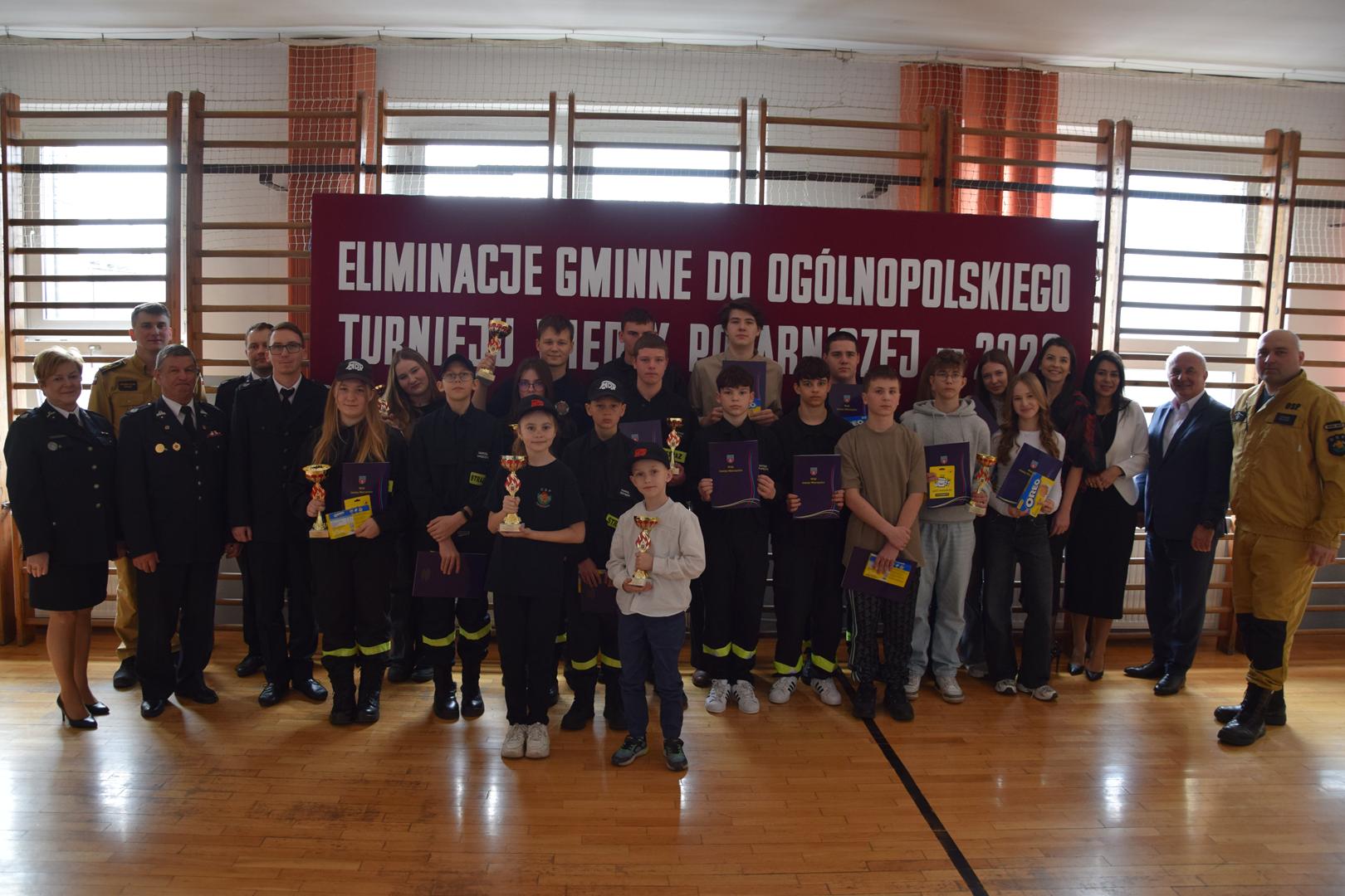 Zdjęcie przedstawia wspólne zdjęcie uczestników turnieju oraz komisji