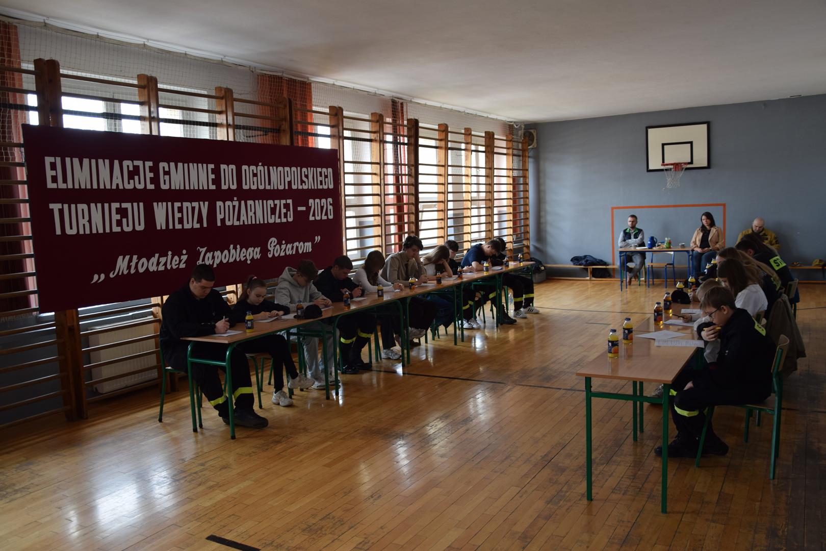 Zdjęcie przedstawia uczestników turnieju podczas pisania