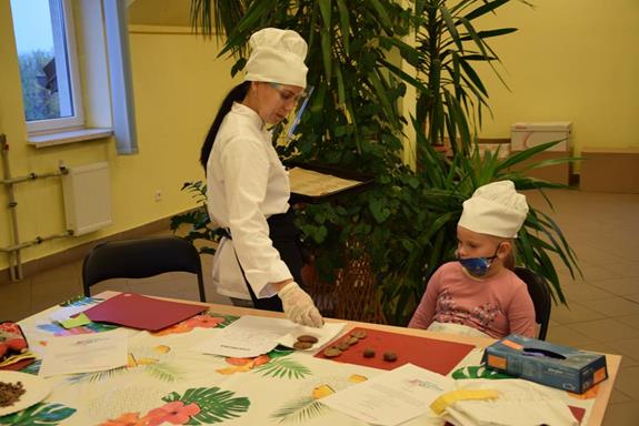 Warsztaty kulinarne - instruktorka rozdaje upieczone ciasteczka
